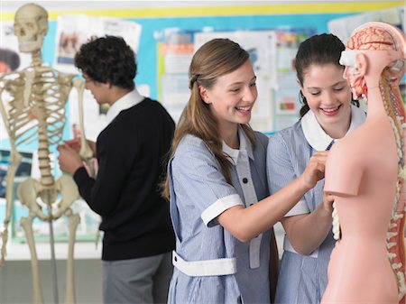 Two laughing high school students examining part of anatomical model, in classroom Stock Photo - Premium Royalty-Free, Code: 693-06018527