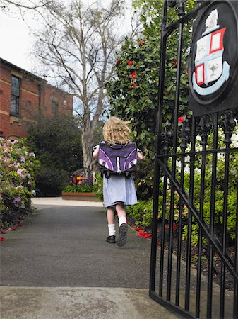 Elementary schoolgirl walking towards school building, back view Stock Photo - Premium Royalty-Free, Code: 693-06018562