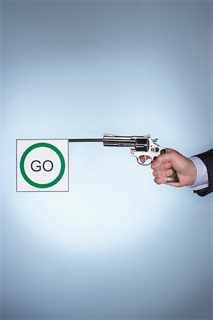 Man firing pistol with go flag, close-up of hand Stock Photo - Premium Royalty-Free, Code: 693-06018691