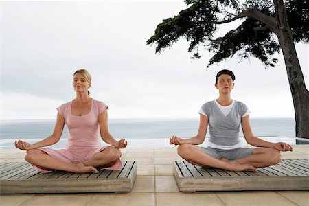 simsearch:640-03265635,k - Two women sitting in yoga positions on terrace Stock Photo - Premium Royalty-Free, Code: 693-06019149