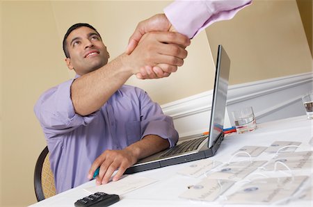 Two men shaking hands over desk with name tags Stock Photo - Premium Royalty-Free, Code: 693-06019615