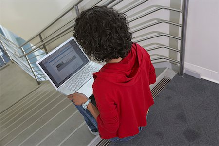 Female student using laptop on stairs Stock Photo - Premium Royalty-Free, Code: 693-06019954