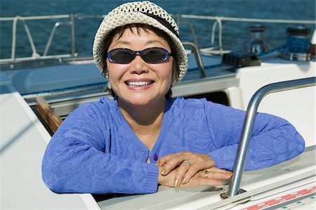 simsearch:693-06013662,k - Femme portant des lunettes de soleil sur le voilier, souriant, (portrait) Photographie de stock - Premium Libres de Droits, Code: 693-06013656