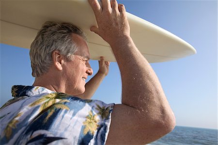 surfboard close up - Male surfer carrying surfboard at ocean Stock Photo - Premium Royalty-Free, Code: 693-06013728