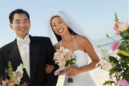 simsearch:693-06013662,k - Jeunes mariés avec des fleurs sur la plage, (portrait) Photographie de stock - Premium Libres de Droits, Code: 693-06013775