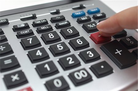 Person using calculator, close-up of finger Stock Photo - Premium Royalty-Free, Code: 693-06020360