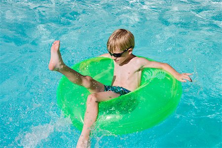 Boy on Float Tube in Swimming Pool Stock Photo - Premium Royalty-Free, Code: 693-06020737