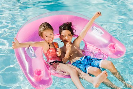 preteen girl floating on water - Children Playing on Inflatable Toy in Swimming Pool Stock Photo - Premium Royalty-Free, Code: 693-06020738
