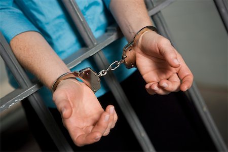 Criminal handcuffed to bars in jail Foto de stock - Sin royalties Premium, Código: 693-06021050