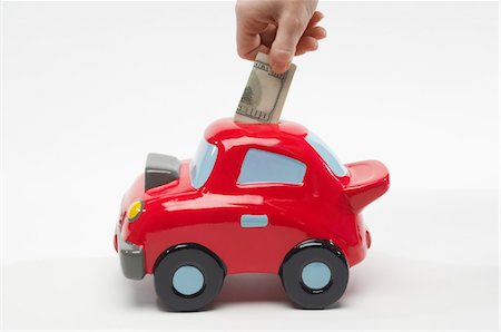 simsearch:693-06021323,k - Hand Putting Money in Car Shaped Piggy Bank Stock Photo - Premium Royalty-Free, Code: 693-06021344