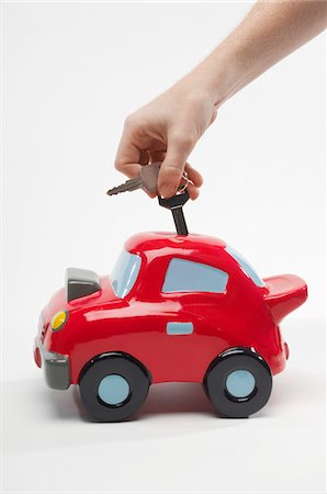 simsearch:693-06021323,k - Hand Putting Car Keys in Car Shaped Piggy Bank Stock Photo - Premium Royalty-Free, Code: 693-06021342
