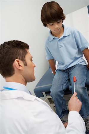 simsearch:694-03331631,k - Doctor examining boy with reflex hammer Stock Photo - Premium Royalty-Free, Code: 693-06021407
