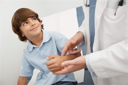 Doctor checking boys pulse Stock Photo - Premium Royalty-Free, Code: 693-06021403