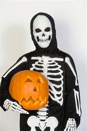 skeletons human not illustration not xray - Portrait of child (7-9) wearing skeleton costume, with jack-o-lantern Stock Photo - Premium Royalty-Free, Code: 693-06021625