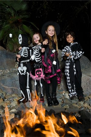 skeletons human not illustration not xray - Girls and boys (7-9) wearing Halloween costumes, cooking marshmallows on campfire Stock Photo - Premium Royalty-Free, Code: 693-06021637
