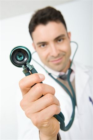 simsearch:693-06022049,k - Mid adult doctor smiling and holding stethoscope Foto de stock - Sin royalties Premium, Código: 693-06022053