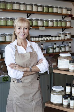 shelves at a grocery store - Portrait of a happy senior woman with arms crossed in spice store Stock Photo - Premium Royalty-Free, Code: 693-06120760