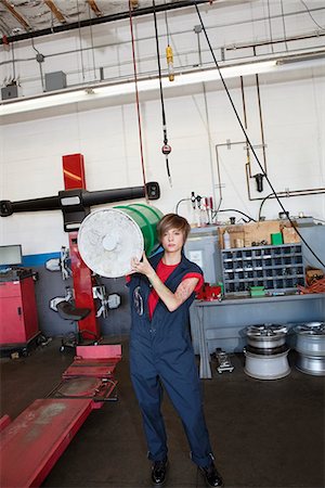 drum - Portrait of a young female mechanic carrying oil drum on shoulder in auto repair garage Stock Photo - Premium Royalty-Free, Code: 693-06120968