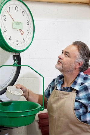 store clerk standing - Mature man looking up at weight scale Foto de stock - Sin royalties Premium, Código: 693-06121161