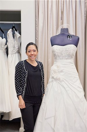 Portrait of a mature employee standing by elegant wedding dress in bridal store Stock Photo - Premium Royalty-Free, Code: 693-06121243