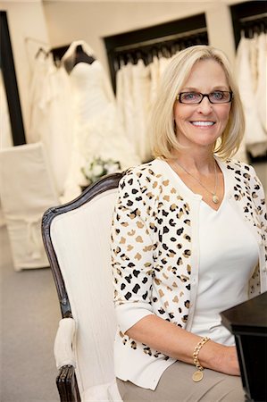 simsearch:693-05794538,k - Portrait of a happy senior female wearing eyeglasses sitting in bridal boutique Stock Photo - Premium Royalty-Free, Code: 693-06121261