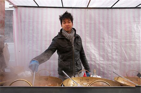 Portrait of a young Asian man cooking at street food stall Stock Photo - Premium Royalty-Free, Code: 693-06121306
