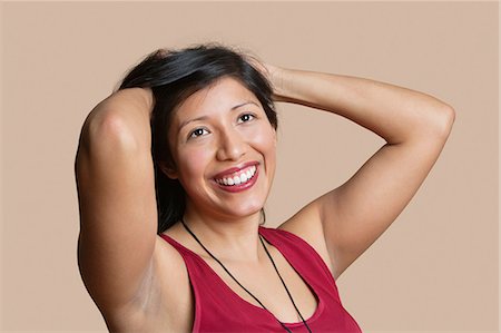 simsearch:693-06324124,k - Beautiful young woman with hands in hair over colored background Stock Photo - Premium Royalty-Free, Code: 693-06121385