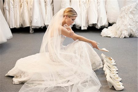 simsearch:693-05794538,k - Side view of young woman in wedding dress confused while selecting footwear Stock Photo - Premium Royalty-Free, Code: 693-06324071