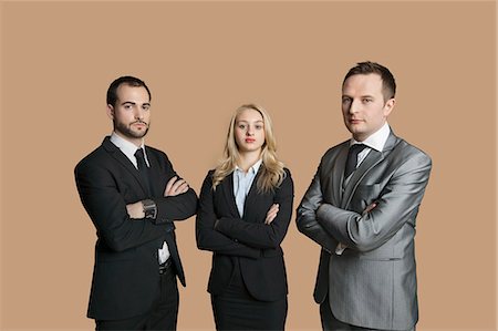 Portrait of young business people with arms crossed over colored background Stock Photo - Premium Royalty-Free, Code: 693-06324164