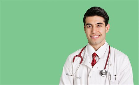 east indian (male) - Portrait of a happy male doctor in lab coat over green background Stock Photo - Premium Royalty-Free, Code: 693-06324238