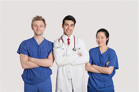 simsearch:693-06324311,k - Portrait of multi ethnic healthcare professionals standing with arms crossed over gray background Stock Photo - Premium Royalty-Free, Code: 693-06324232