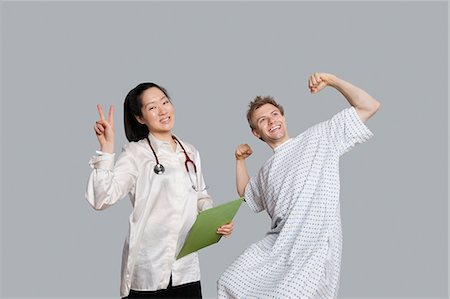 doctor and patient, portrait - Portrait of doctor gesturing peace sign with patient cheering up Stock Photo - Premium Royalty-Free, Code: 693-06324296