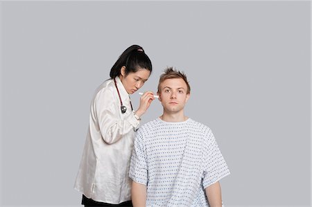 simsearch:693-06324311,k - Doctor examining patient's ear with flashlight Stock Photo - Premium Royalty-Free, Code: 693-06324290