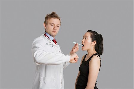 simsearch:693-06324311,k - Doctor checking temperature of female patient Stock Photo - Premium Royalty-Free, Code: 693-06324305