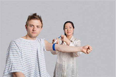 simsearch:693-06324311,k - Portrait of male patient with doctor preparing him for a blood test Stock Photo - Premium Royalty-Free, Code: 693-06324302