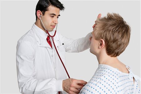 Indian doctor examining male patient with stethoscope Stock Photo - Premium Royalty-Free, Code: 693-06324314