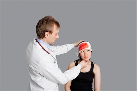 simsearch:693-06324311,k - Male doctor treating female patient over colored background Stock Photo - Premium Royalty-Free, Code: 693-06324312