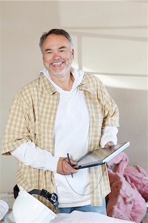 fixing - Happy male architect holding digital tablet pc at construction site Stock Photo - Premium Royalty-Free, Code: 693-06324501