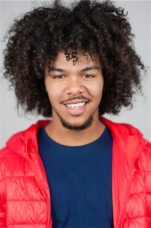 Portrait of a happy man with curly hair and goatee Stock Photo - Premium Royalty-Free, Code: 693-06324725