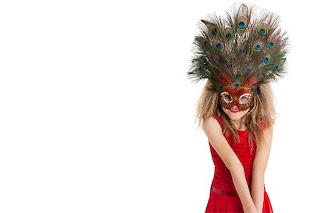 feather headdress - Portrait of a happy girl wearing peacock feather mask over white background Stock Photo - Premium Royalty-Free, Code: 693-06324845