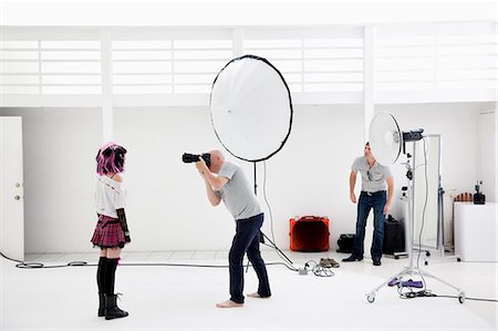 fotógrafo - Photographer shooting fashion model in photo shoot Foto de stock - Sin royalties Premium, Código: 693-06324879