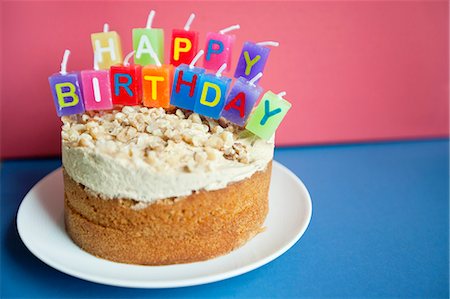 Gros plan des bougies d'anniversaire gâteau torte sur fond coloré Photographie de stock - Premium Libres de Droits, Code: 693-06325233