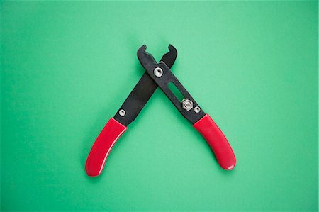Close-up view of duckbill pliers over green background Stock Photo - Premium Royalty-Free, Code: 693-06325250