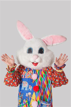 simsearch:693-06380036,k - Man wearing bunny mask with standing raised hands against gray background Foto de stock - Sin royalties Premium, Código: 693-06378833