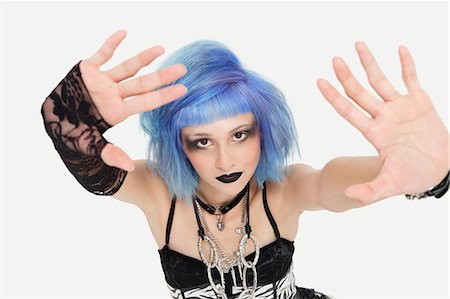 Portrait of young female punk making a stop gesture over gray background Stock Photo - Premium Royalty-Free, Code: 693-06378859