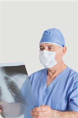 radiographs - Senior male surgeon examining x-ray over gray background Stock Photo - Premium Royalty-Free, Code: 693-06378910