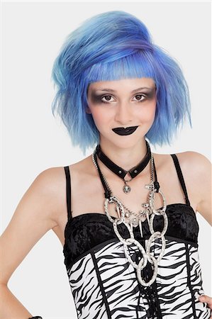 Portrait of young female punk with dyed hair over gray background Stock Photo - Premium Royalty-Free, Code: 693-06378968