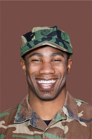 soldiers - Portrait of cheerful, young, African American soldier, Studio Shot on brown background Stock Photo - Premium Royalty-Free, Code: 693-06379134
