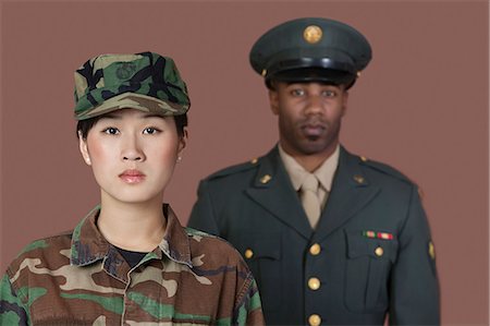 soldier - Portrait of young, female soldier with male officer in background Stock Photo - Premium Royalty-Free, Code: 693-06379166