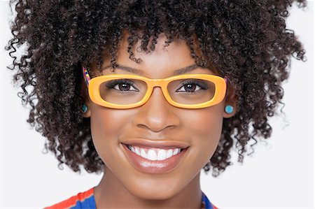 Close-up portrait of an African American woman wearing glasses over gray background Stock Photo - Premium Royalty-Free, Code: 693-06379217